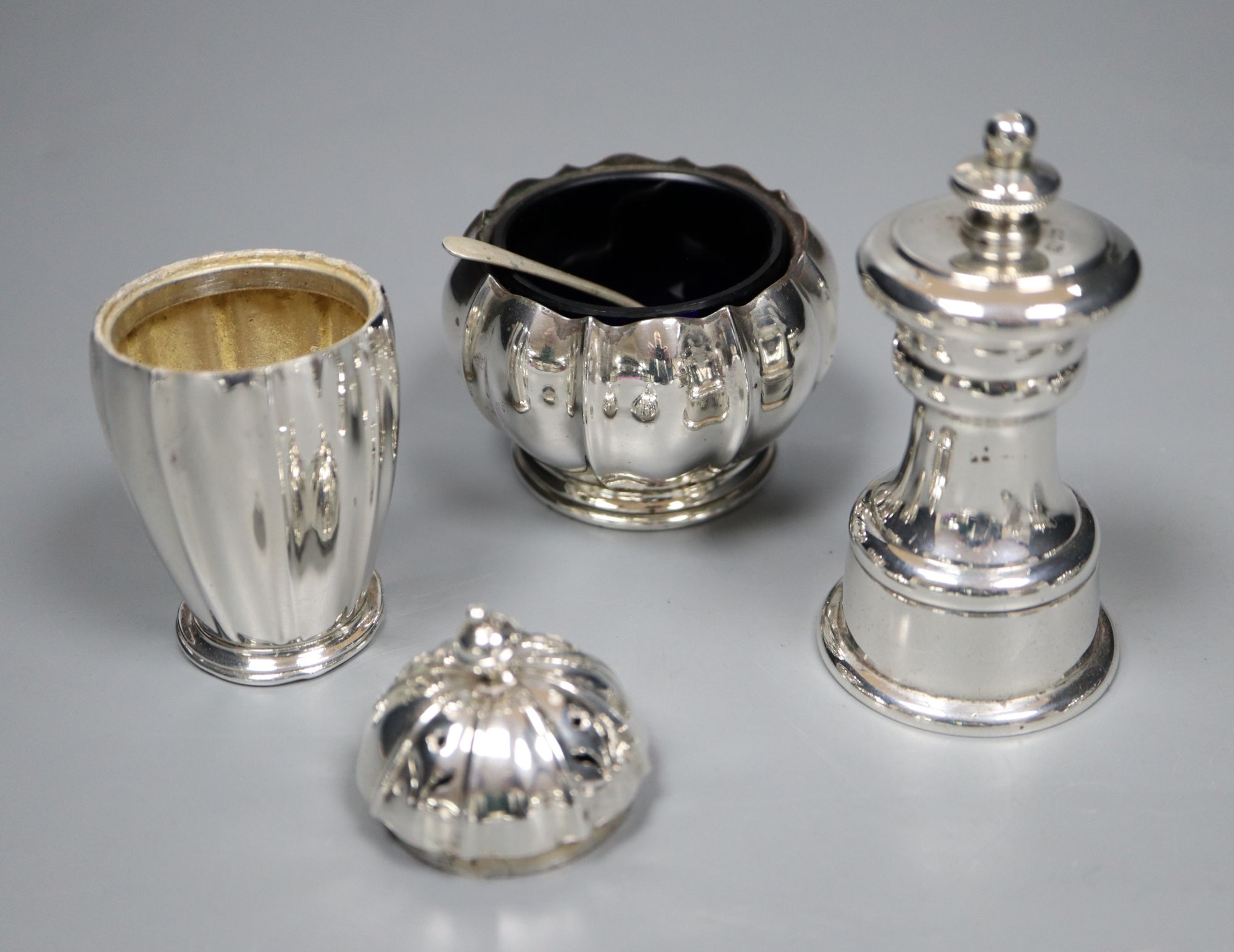 A peppermill, a three piece condiment set, a Victorian christening spoon and a plated lighter